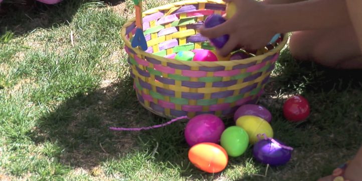 Child Placing Easter Eggs In Basket